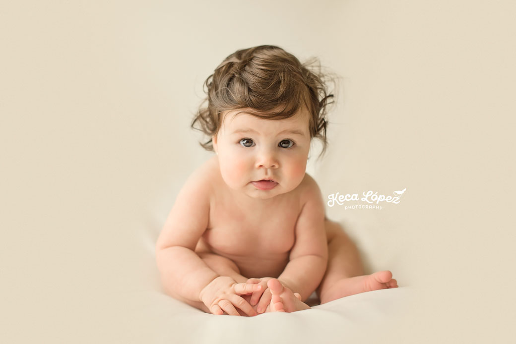 Bebé alegre de 6 meses sentado. Fondo blanco