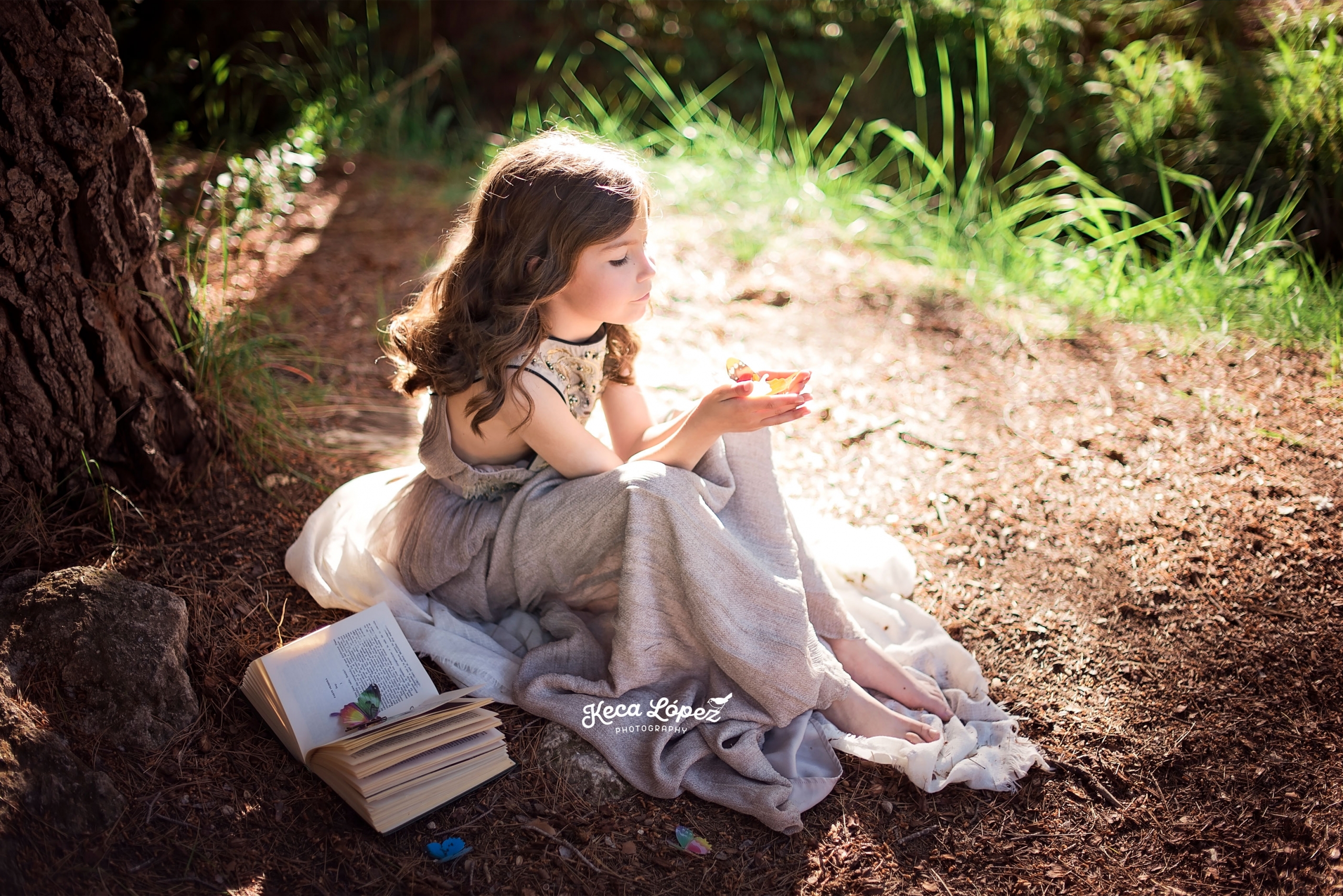 Niña jugando con mariposas en el campo