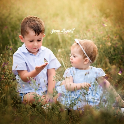 Fotografia hermanos en el campo. Niño con una mariposa