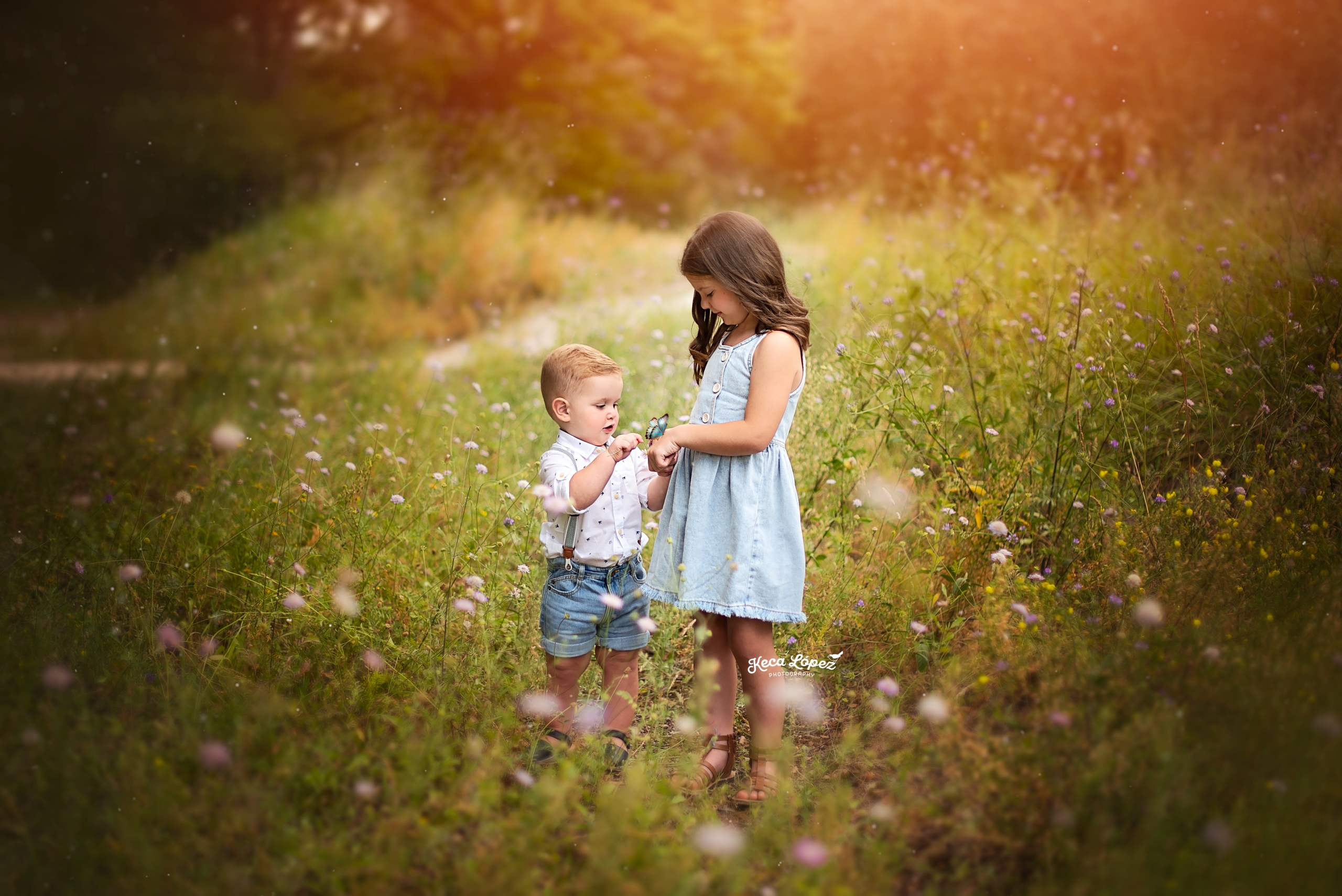 niños en el campo con una mariposa y flores blancas